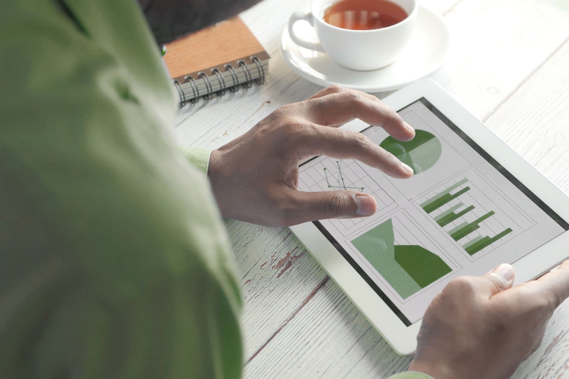 person holding an ipad with graphs and charts of energy usage
